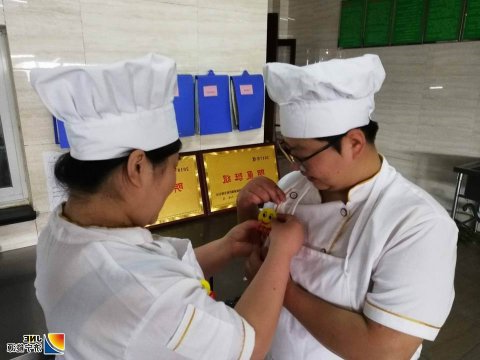 安居煤矿食堂职工佩戴“笑脸牌”上岗